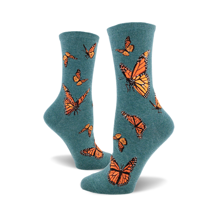 the teal blue socks have a pattern of monarch butterflies. the butterflies are orange, black, and white. }}