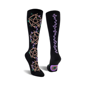 front and back view of black knee-high socks featuring pentagrams woven with twigs and purple flowers.