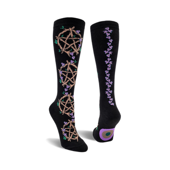 front and back view of black knee-high socks featuring pentagrams woven with twigs and purple flowers.