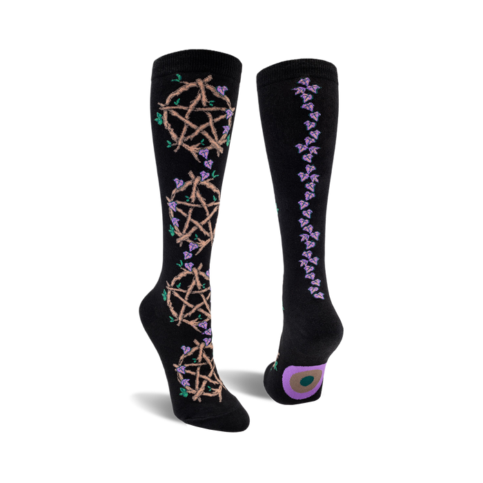 front and back view of black knee-high socks featuring pentagrams woven with twigs and purple flowers. }}