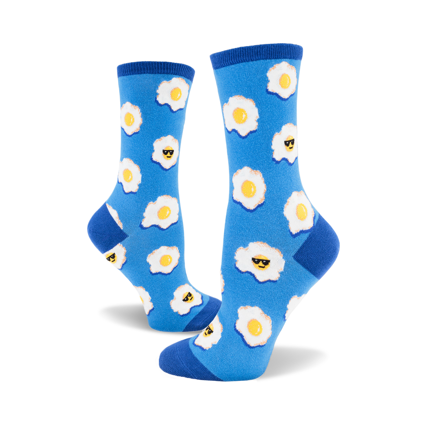 A pair of women's crew socks in blue with a pattern of fried eggs wearing sunglasses. Yellow yolks and white egg whites stand out on the vibrant blue background.