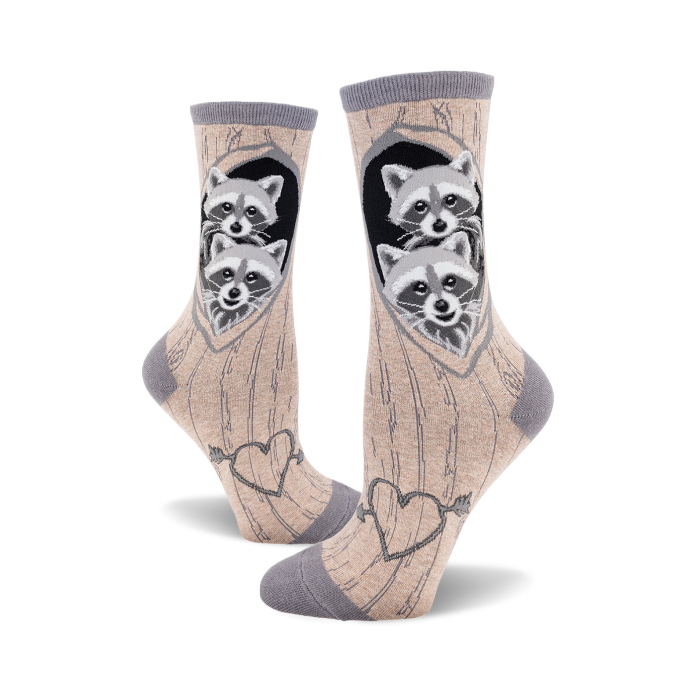 Crew socks in beige and grey featuring two raccoons peeking from a tree heart, with an arrow-pierced heart design at the bottom.