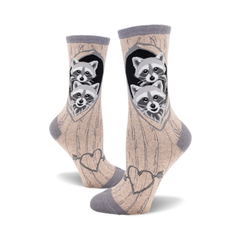 side view of two crew socks with raccoons peeking out of a tree trunk. the socks have hearts and an arrow on the bottom.