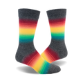 Pair of crew socks in charcoal grey with a horizontal dark rainbow stripe design.  Colors include red, orange, yellow, green, and teal.