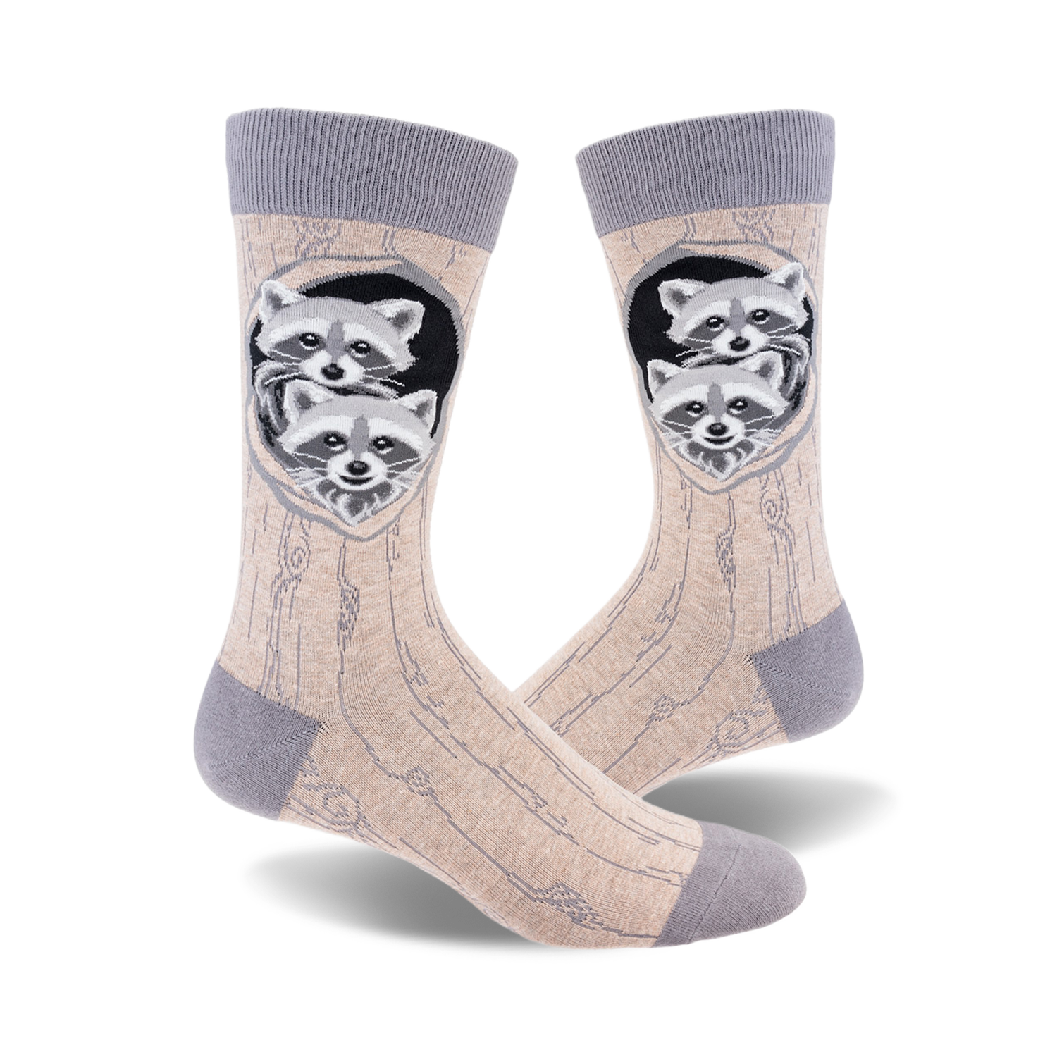 A pair of beige crew socks with a grey cuff.  The design shows two raccoons peeking out of a tree trunk hole.