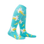 Lifestyle shot: Model wearing teal Bananarwhal knee-high socks, showcasing the fit and fun design.