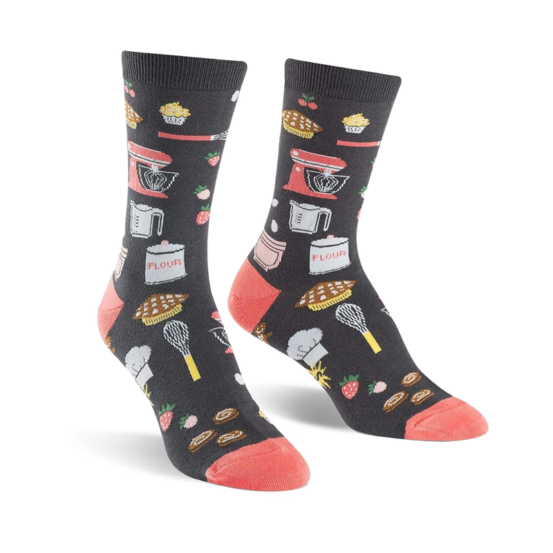 Pair of crew socks in dark gray with coral toes and heels.  The socks are adorned with illustrations of kitchen tools, baked goods, and strawberries.
