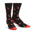 Pair of black crew socks with a pattern of red hot sauce bottles and chili peppers. Red accents on the cuffs.