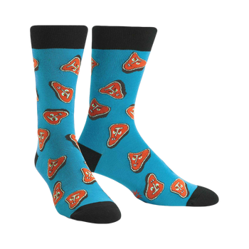 Pair of teal crew socks featuring a pattern of cartoonish orange steaks. Black cuffs and toes.