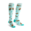 Pair of teal knee-high socks with a pattern of brown otters holding hands and small hearts.  Simple leaf designs are also scattered on the socks.