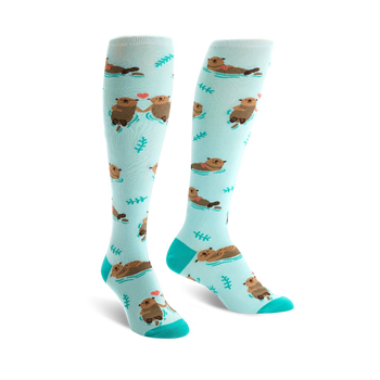 light blue knee high women's socks with cartoon otters holding hands and green plants.  