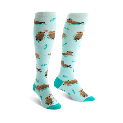 light blue knee high women's socks with cartoon otters holding hands and green plants.  