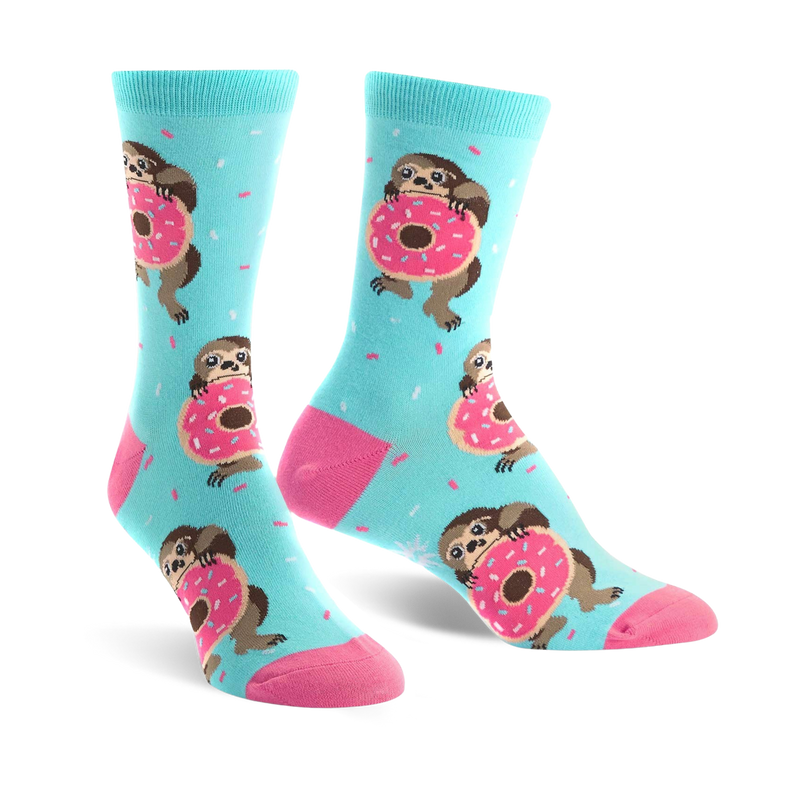 A pair of pastel blue crew socks features sloths hugging pink donuts and light blue sprinkles.  The socks have pink heels and toes.