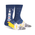 A pair of men's crew socks; one sock shows a rocket launching, the other shows a starry night sky.  Colors are navy blue, yellow, white, and gray.