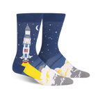 A pair of men's crew socks; one sock shows a rocket launching, the other shows a starry night sky.  Colors are navy blue, yellow, white, and gray.