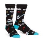 Pair of black crew socks with a jazz-themed design. Features musical instruments, notes, and piano keys, accented with teal at the cuff.