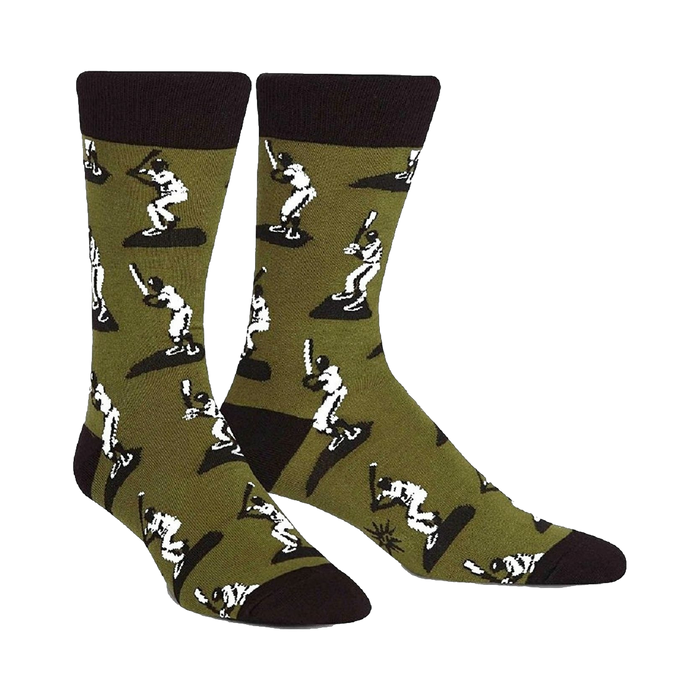 A pair of men's crew socks in olive green with a repeating pattern of white baseball players batting. The socks have black cuffs. }}