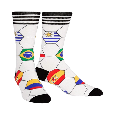 A pair of crew socks with a white soccer ball design.  National flags from various countries are featured in the hexagons. Black and white stripes at the top.