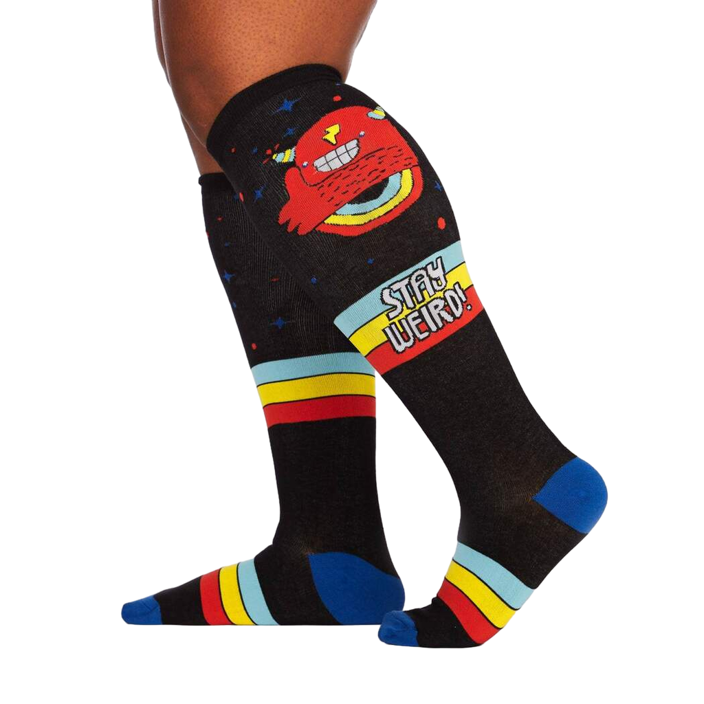 Lifestyle shot of a person wearing the 'Stay Weird!' knee-high socks, showcasing the socks' design and fit.