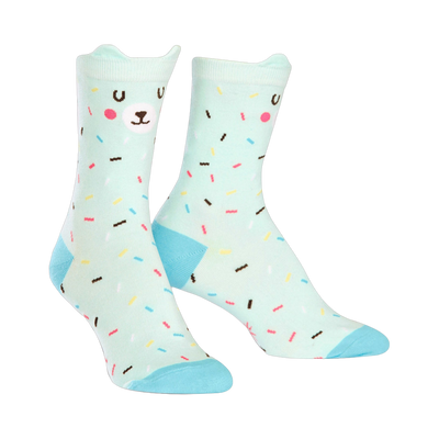 Pair of mint green crew socks with a cute bear face and colorful sprinkles design. Light blue heel and toe.