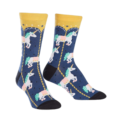 Crew socks in navy blue with a pattern of white unicorns riding a gold carousel. Yellow cuffs and pink, green details.