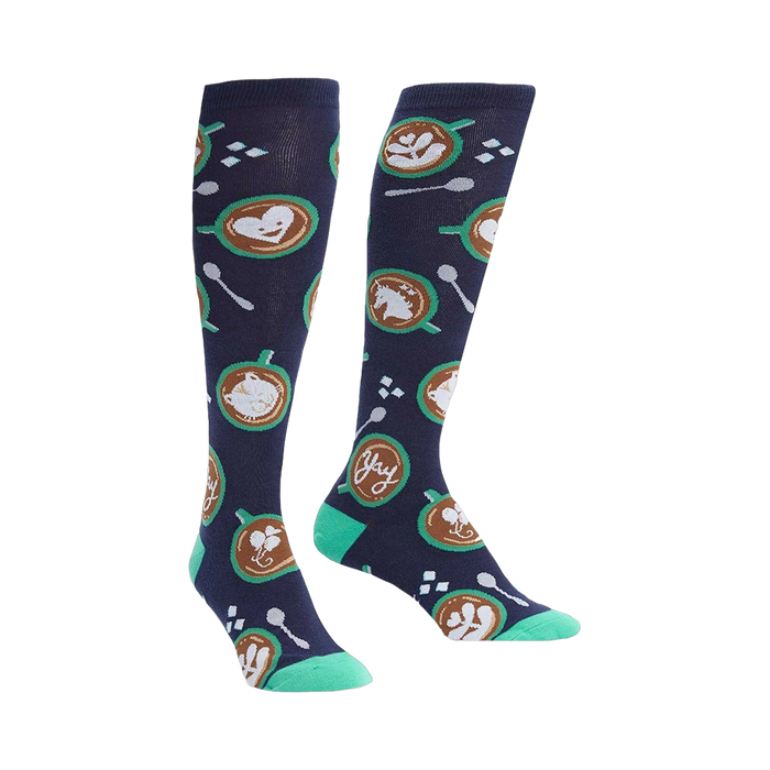 Pair of navy blue knee-high socks with latte art (hearts, horses, cats), teal spoons, and sugar cubes. }}