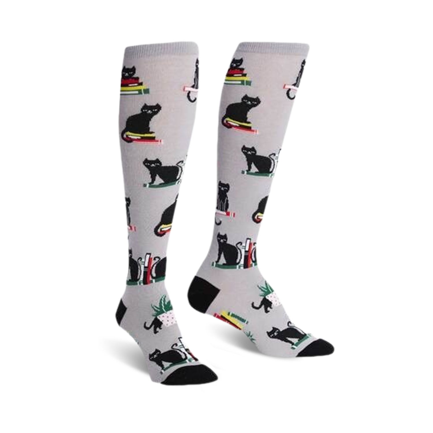 Pair of knee-high socks on a white background.  They're light grey with a pattern of black cats sitting on stacks of colorful books.