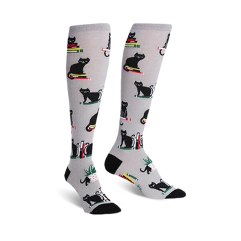 gray knee-high women's socks with a pattern of black cats sitting on books.  