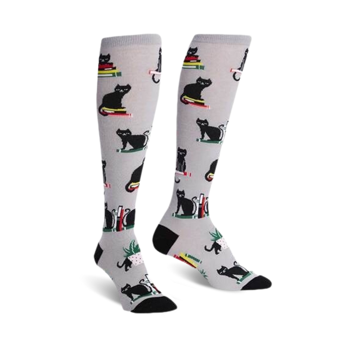 gray knee-high women's socks with a pattern of black cats sitting on books.   }}