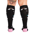 Rear view of a person wearing the 'Keep Dreamin' knee-high socks, highlighting the back design.