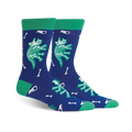 Crew socks in navy blue and teal green, featuring glow-in-the-dark dinosaur skeletons and bones. Fun and quirky design.