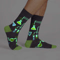 A pair of glow-in-the-dark 'Laboratory' socks shown on a model's legs, showcasing the design.