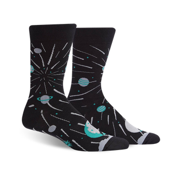 A pair of black crew socks with teal planets, shooting stars, and a celestial design.
