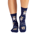 Lifestyle shot showing the socks on a person's legs. The socks are navy blue with pugs dressed as astronauts.
