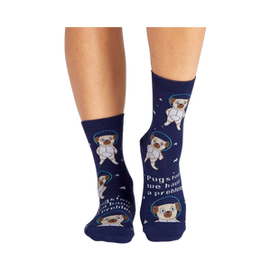 Lifestyle shot showing the socks on a person's legs. The socks are navy blue with pugs dressed as astronauts.