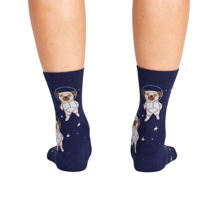 A pair of blue socks with a repeating pattern of cartoon pugs in space suits against a background of stars.