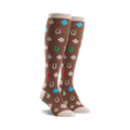 Pair of brown knee-high socks featuring a pattern of four-leaf clovers, horseshoes, ladybugs, and the number seven in various colors.