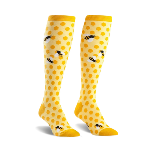 Pair of yellow knee-high socks with a honeycomb pattern and cute bee illustrations.