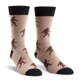 Sasquatch crew socks with brown Bigfoot figures on tan, featuring black cuffs, heels, and toes.