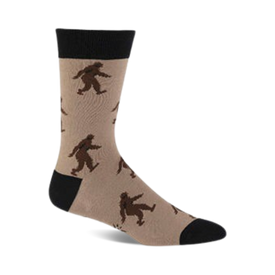 brown and black crew socks featuring a pattern of black and brown sasquatches skiing, with a black toe and heel and a tan top.  