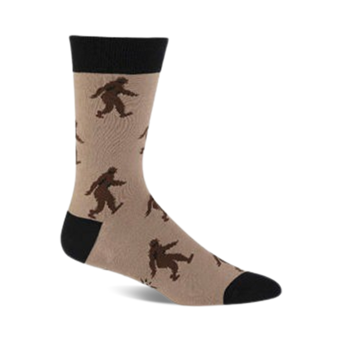 brown and black crew socks featuring a pattern of black and brown sasquatches skiing, with a black toe and heel and a tan top.   }}