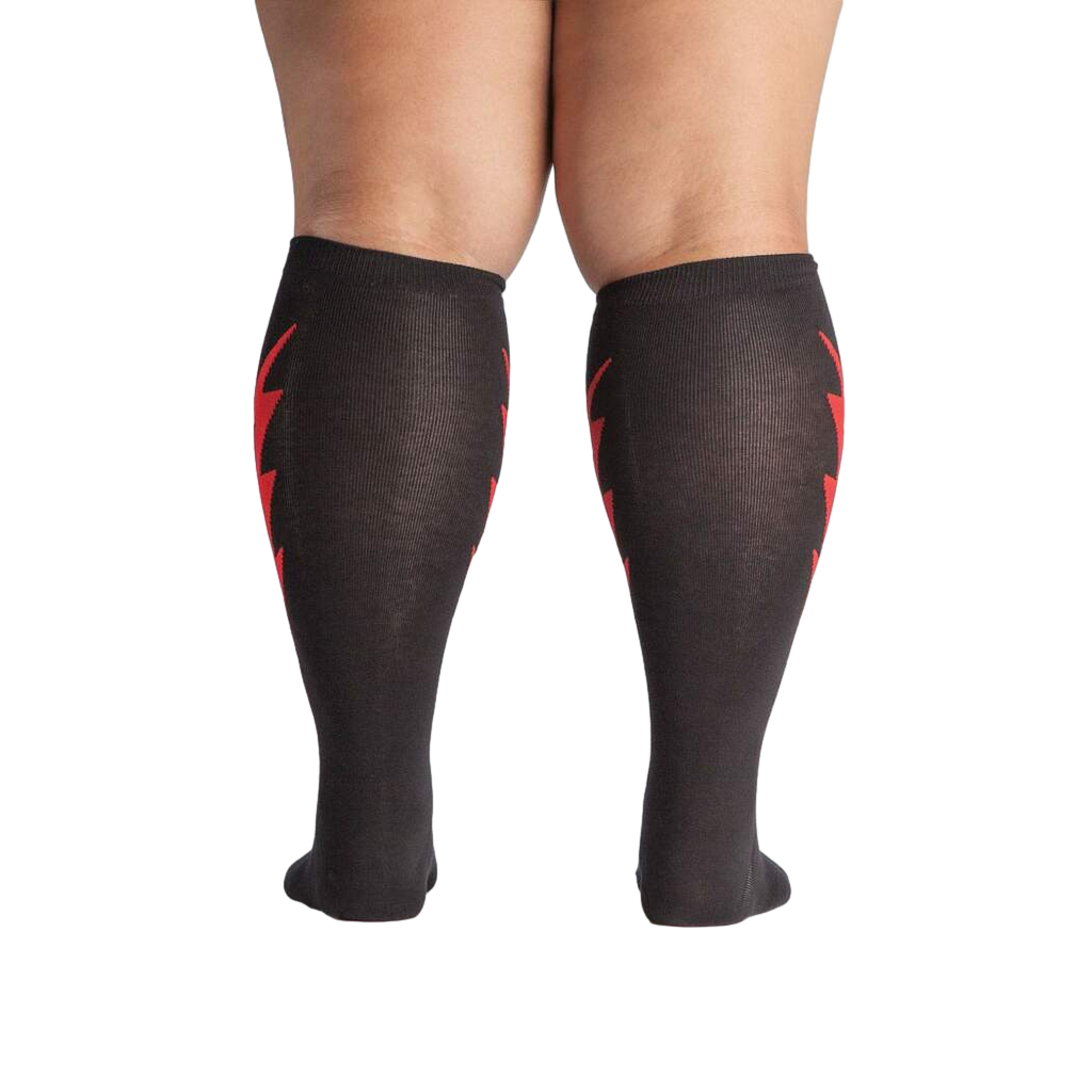 Rear view of a person wearing the black knee-high socks with red lightning bolts.