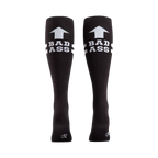 Rear view of a pair of black 'Bad Ass' knee-high socks on a person's legs.