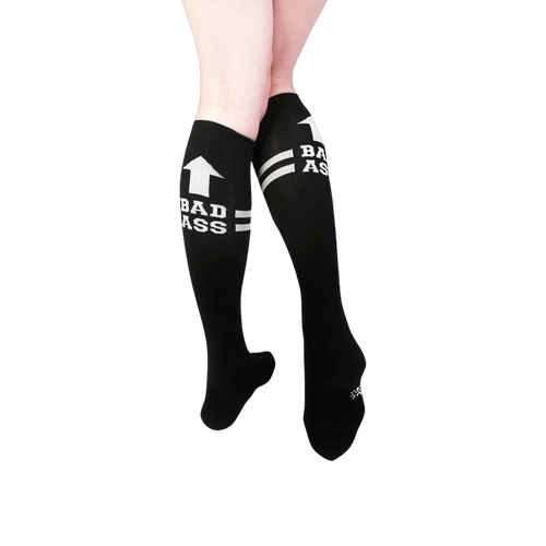 Pair of black knee-high socks with white stripes and 'Bad Ass' text.  Features an upward-pointing arrow graphic.