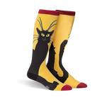 A pair of knee-high socks in mustard yellow with a black cat design. The cat is stylized and sits against the yellow background.