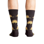 Back view of a person wearing Tacosaurus socks.  The image shows the complete sock design and a hint of the sock's cuff.