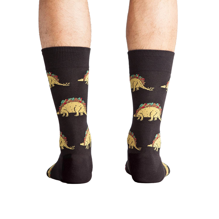 Back view of a person wearing Tacosaurus socks.  The image shows the complete sock design and a hint of the sock's cuff.