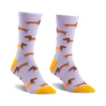 Pair of lavender crew socks featuring a repeating pattern of brown dachshunds and one dachshund shaped like a hot dog. Yellow accents at the cuffs.