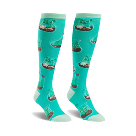 mint green knee-high socks for women featuring a pattern of terrariums with brown soil, green plants, and white rocks. botanical theme.  
