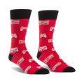 Pair of red crew socks with black cuffs.  Features a pattern of white video game controllers and consoles.